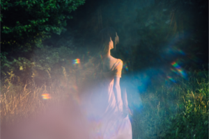 vrouw die tijdens een spirituele reiniging door een veld loopt